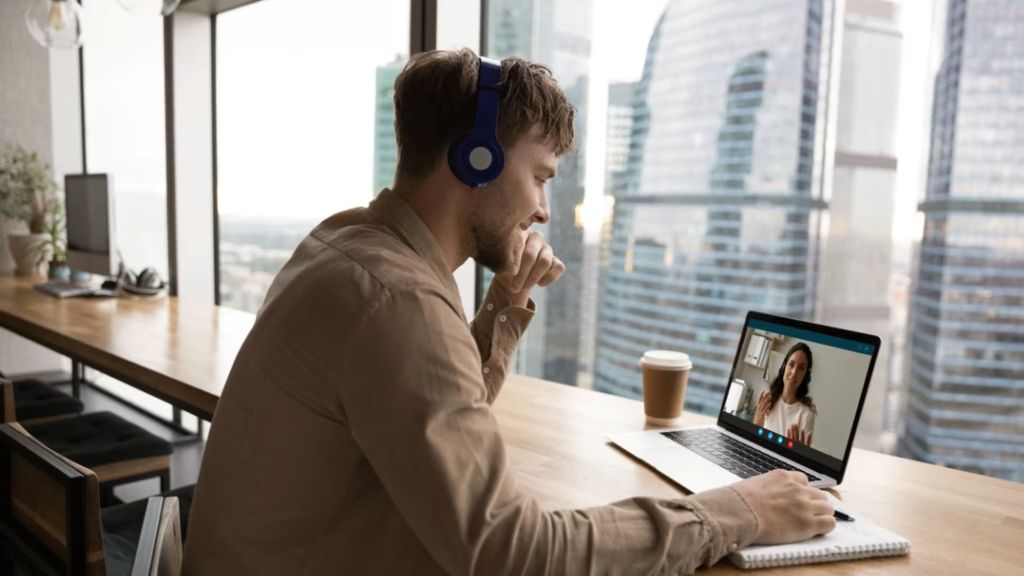 Team members collaborating via video call on collaboration software in a home office environment.