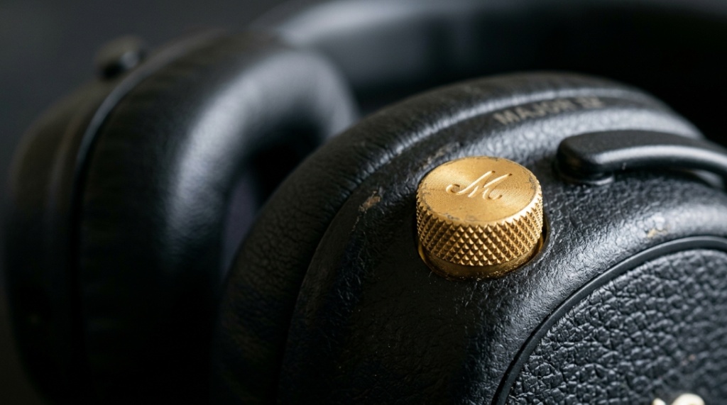 Close-up of the gold control knob on the side of Marshall headphones.